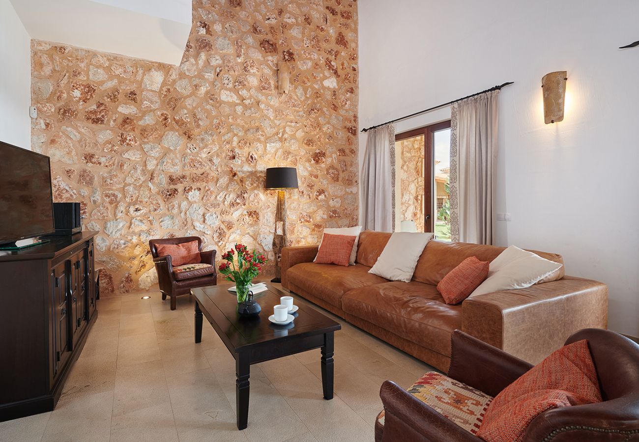 Stilvolles Wohnzimmer mit Sofa und Fernseher in der Finca Casa Fortuna bei Manacor