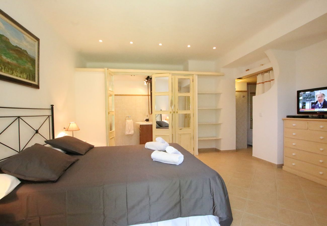 Schlafzimmer mit Doppelbett und Bad der Finca Ca Na Barbara in Santanyi