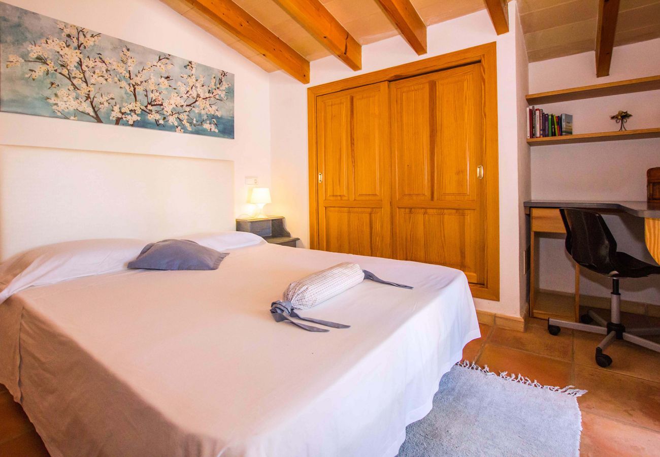 Schlafzimmer mit Doppelbett und Bad der Finca Tovell bei Son Carrió 