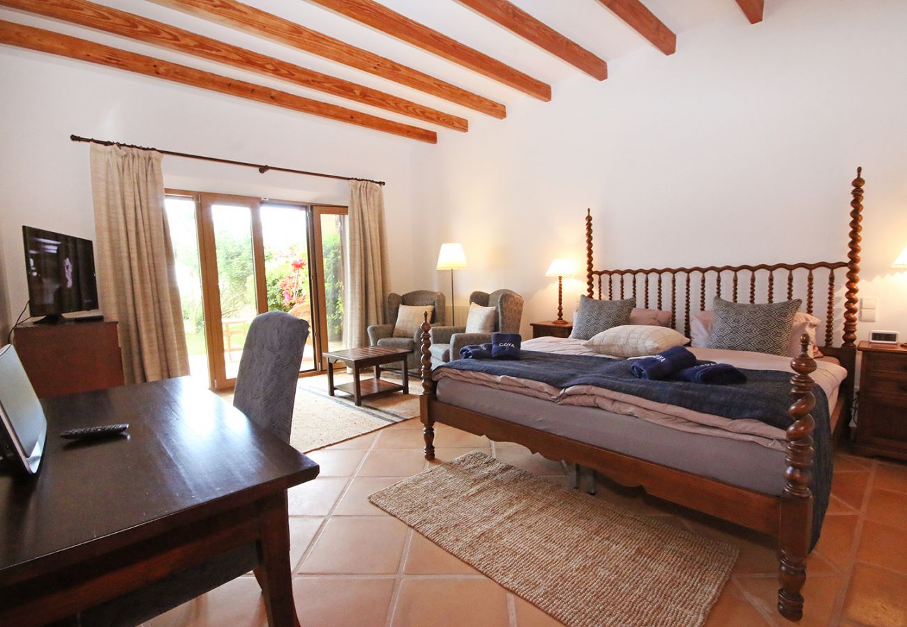Schlafzimmer mit Doppelbett, Bad und Sessel in der Finca Can Ferragut bei Porto Cristo