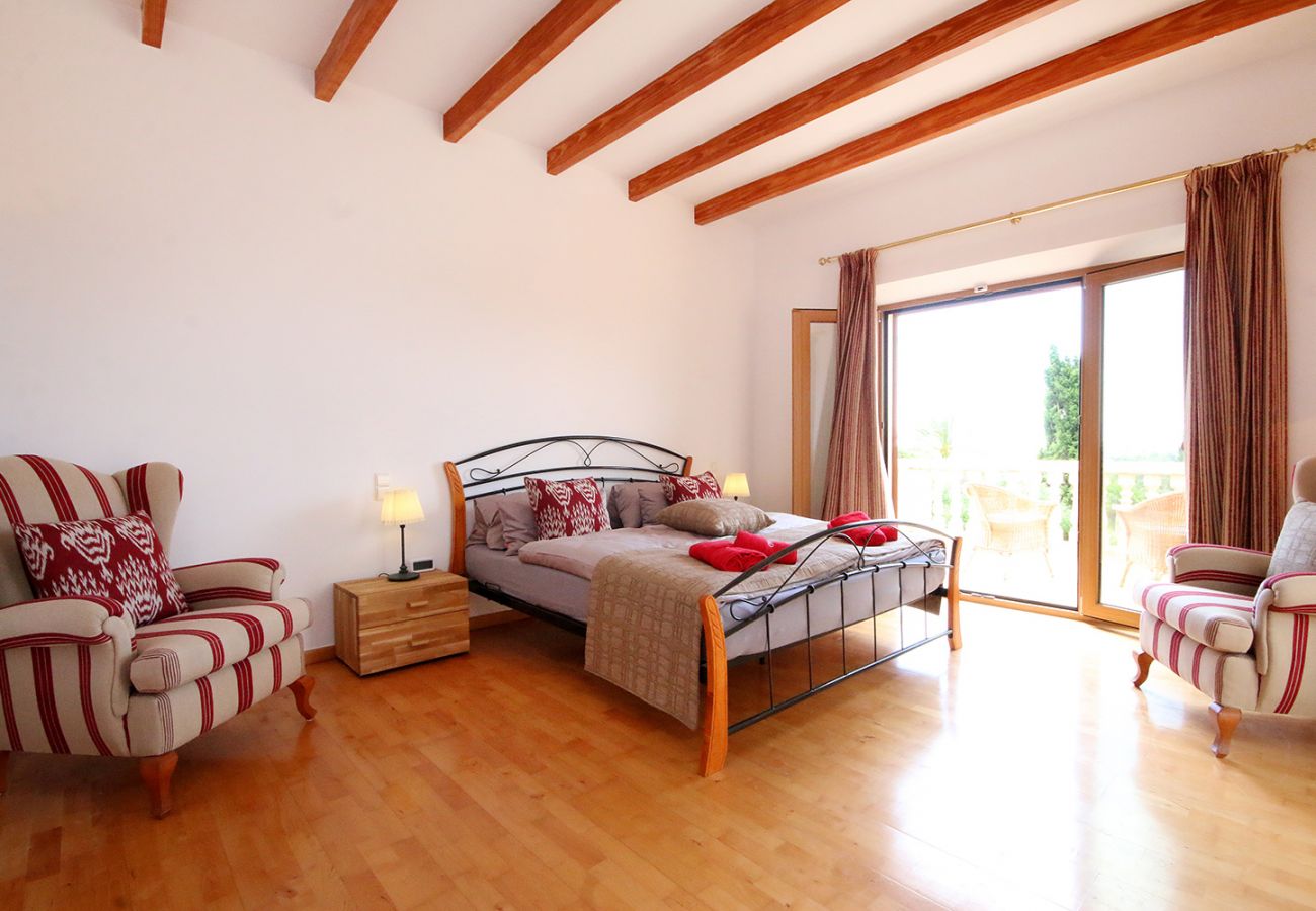 Schlafzimmer mit Doppelbett, Bad und Sessel in der Finca Can Ferragut bei Porto Cristo