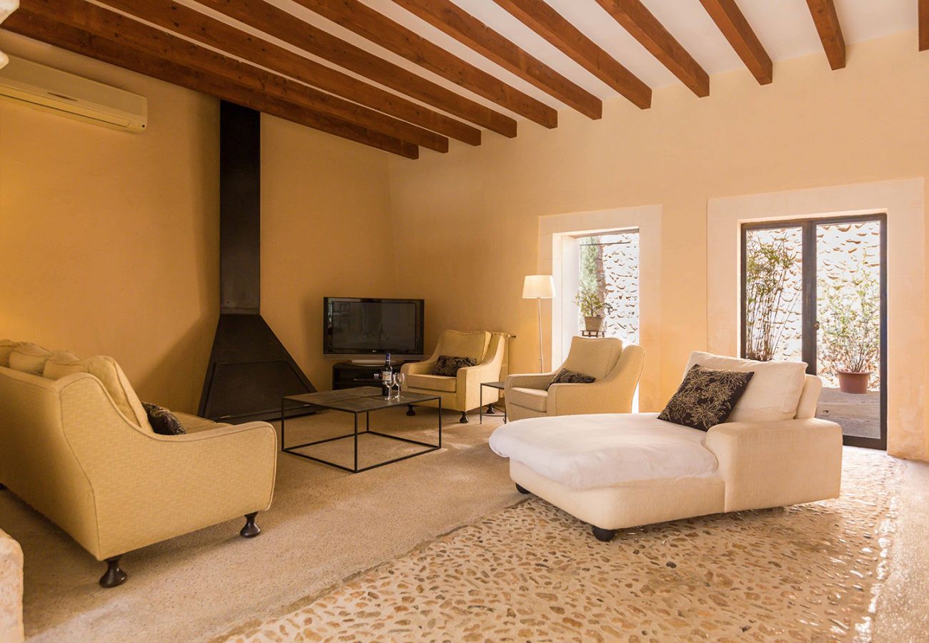 modernes Wohnzimmer mit Kamin, Fernseher und Sofas der Finca Tomeu Buger bei Buger