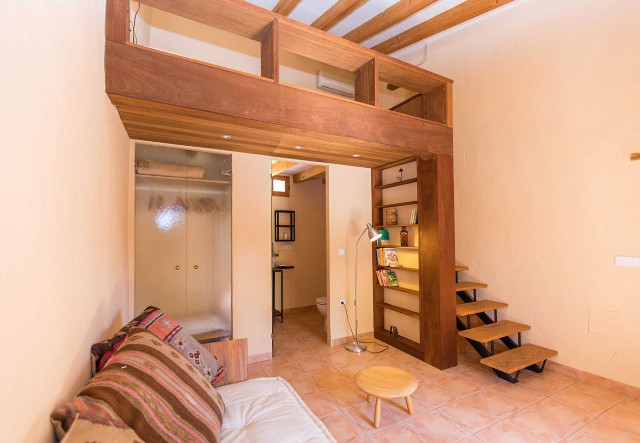 Schlafzimmer mit Doppelbett, Sofa und eigenem Bad der Finca Tomeu Buger bei Buger