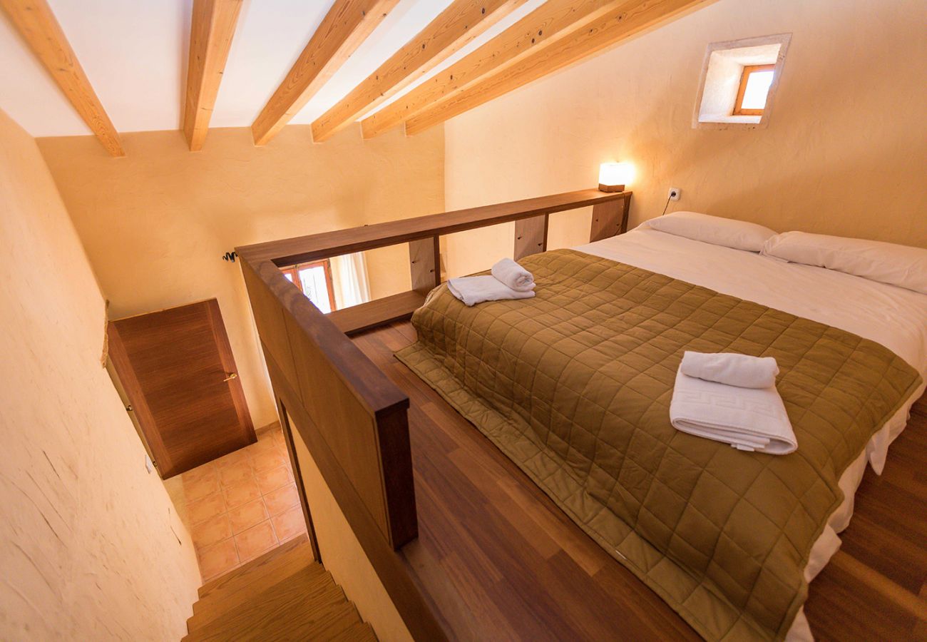 Schlafzimmer mit erhöhtem Doppelbett der Finca Tomeu Buger bei Buger