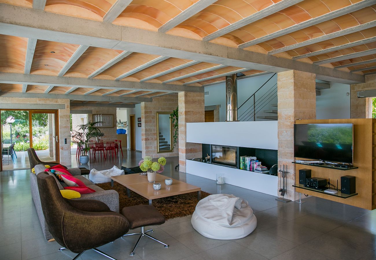 großes Wohnzimmer mit modernem Kamin und Sitzecke in der Finca Es Puig in Felanitx