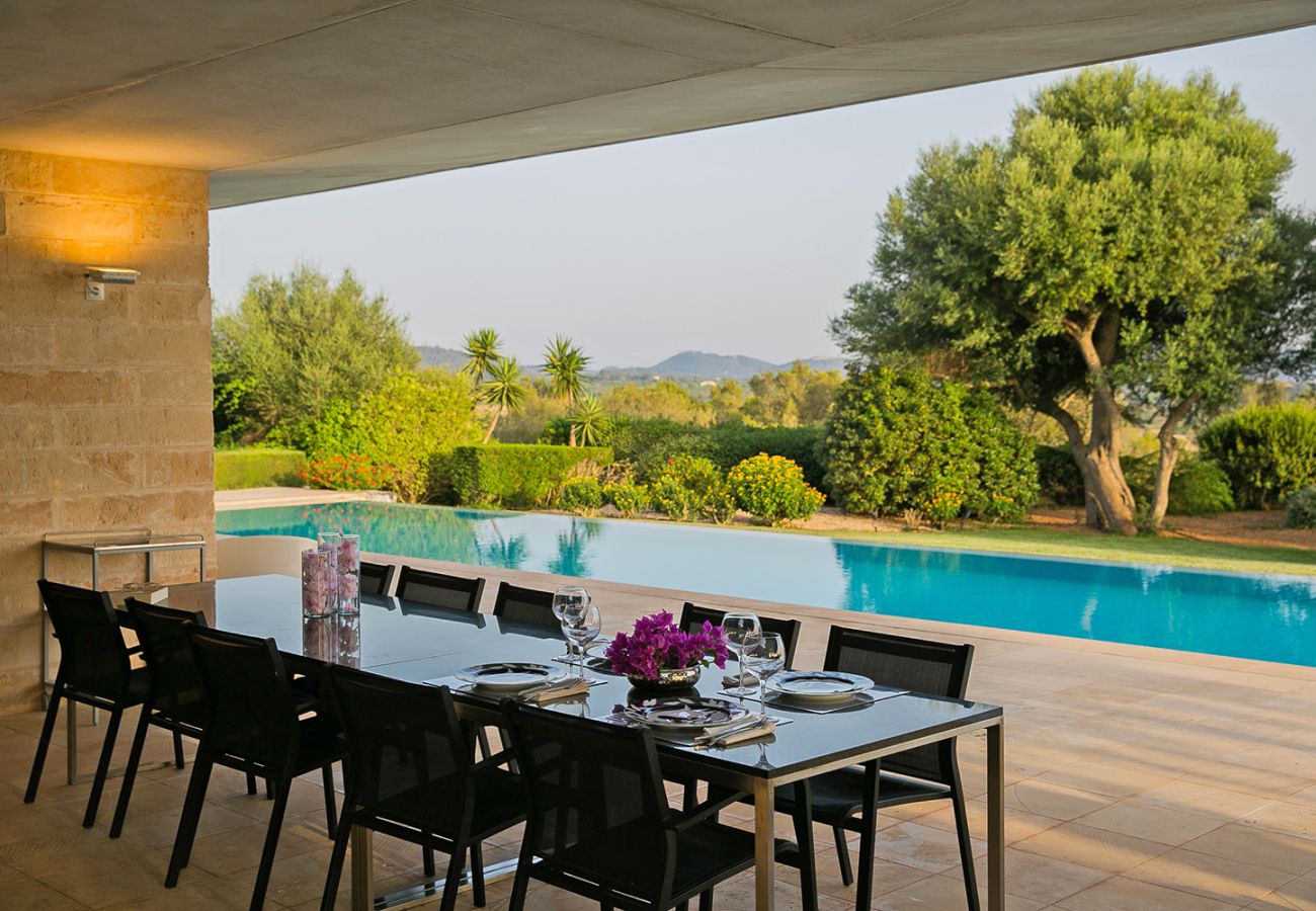 großer Tisch auf der überdachten Terrasse am Pool der Finca Es Puig in Felanitx