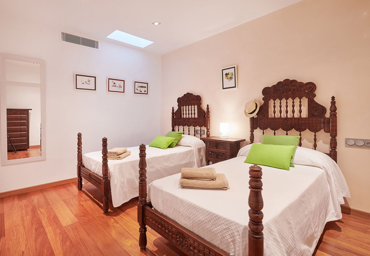 Schlafzimmer mit zwei rustikalen Betten der Ferienwohnung Faro I in Portocolom