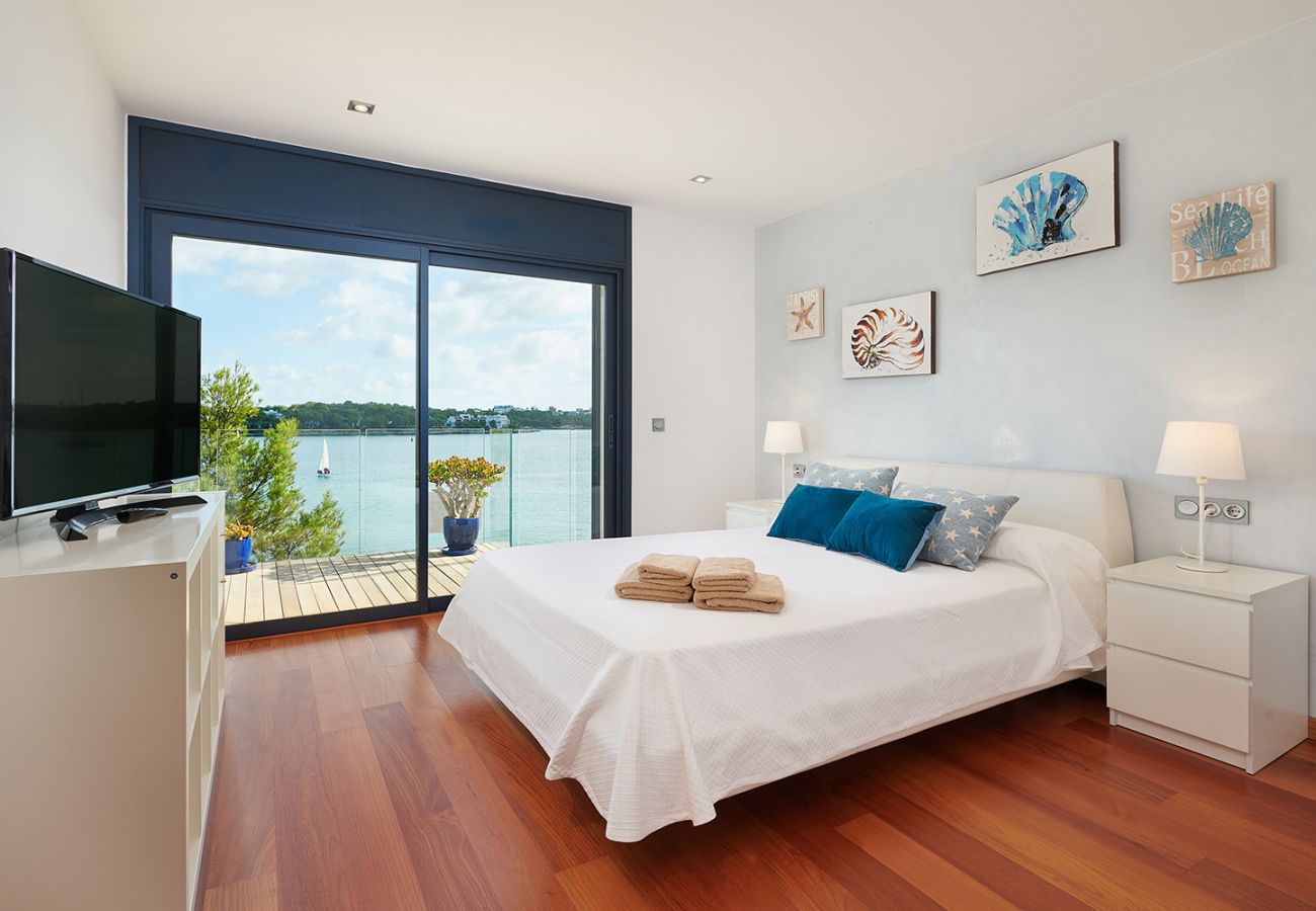 helles Schlafzimmer mit Doppelbett und Bad en Suite der Ferienwohnung Faro II in Portocolom