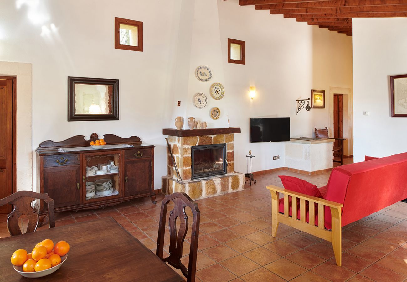 Wohnzimmer mit Kamin und Sofa der Finca Els Ermassos bei Felanitx