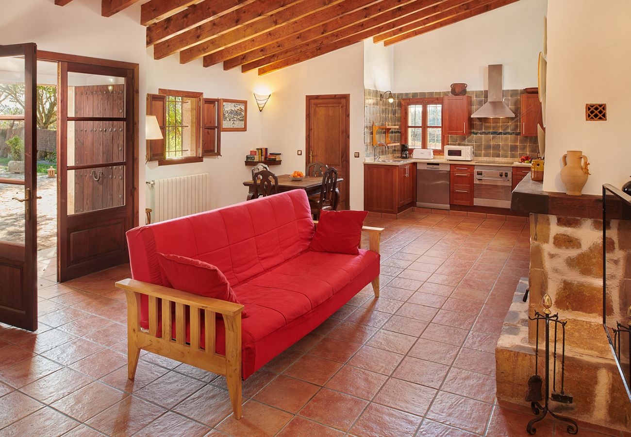 Wohnzimmer mit offener Küche und Blick in den Garten der Finca Els Ermassos bei Felanitx
