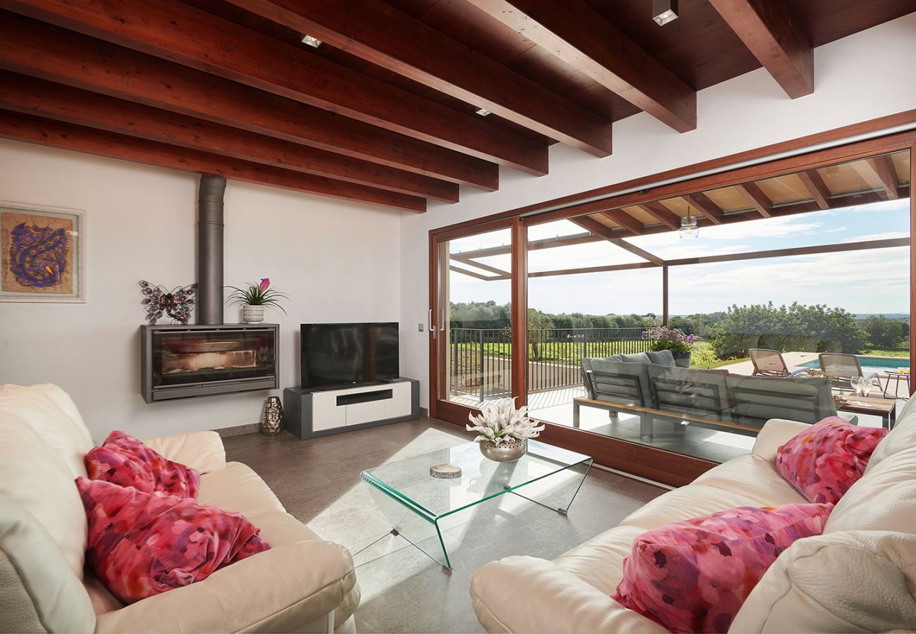 Stilvolles Wohnzimmer mit Ofen und Blick auf die Terrasse der Finca Can Maimo bei Santanyi