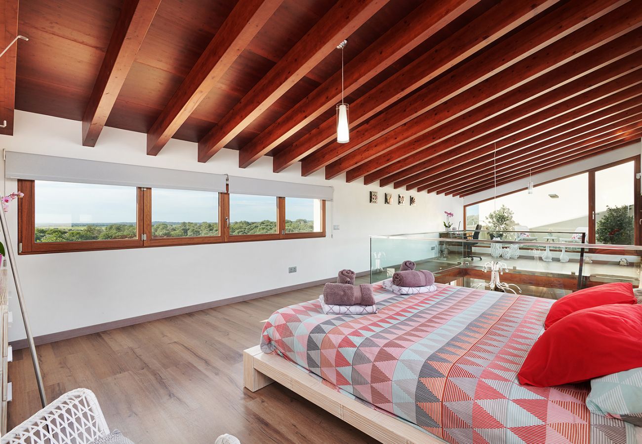 Schlafzimmer mit Doppelbett und Balkon auf der Galerie der Finca Can Maimo bei Santanyi