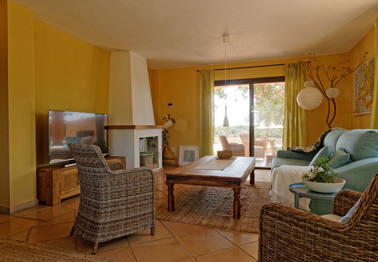 Wohnzimmer mit Kamin und Sofa in der Finca El Retiro in Ses Salines