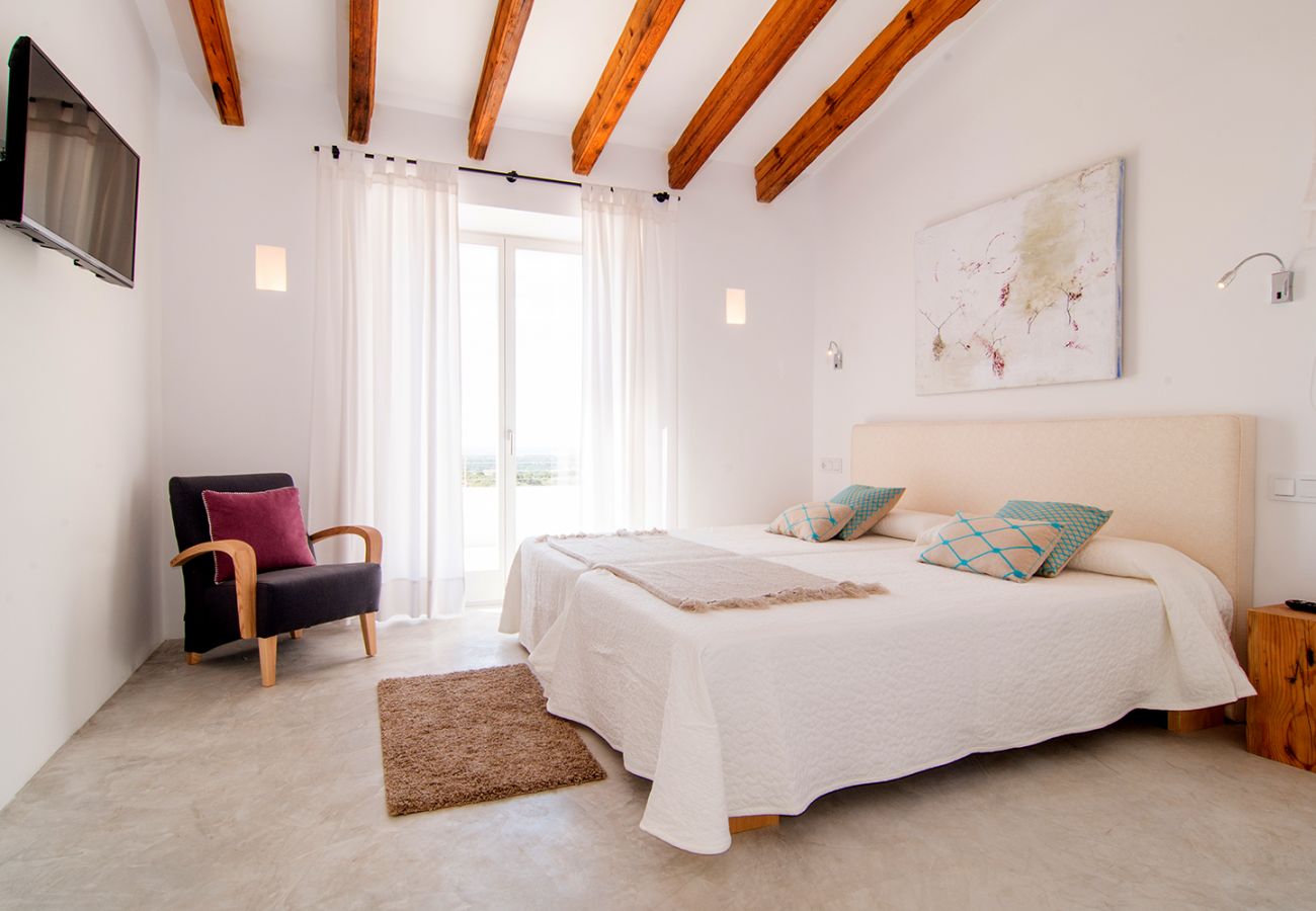 Schlafzimmer mit zwei Einzelbetten und Sessel der Finca Can Duai in Sant Llorenç Des Cardassar 