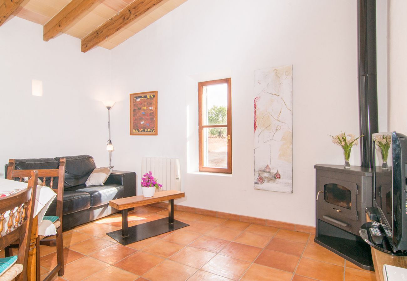 Ess- und Wohnzimmer der Finca Bonita bei Son Servera mit Ofen und Sofa