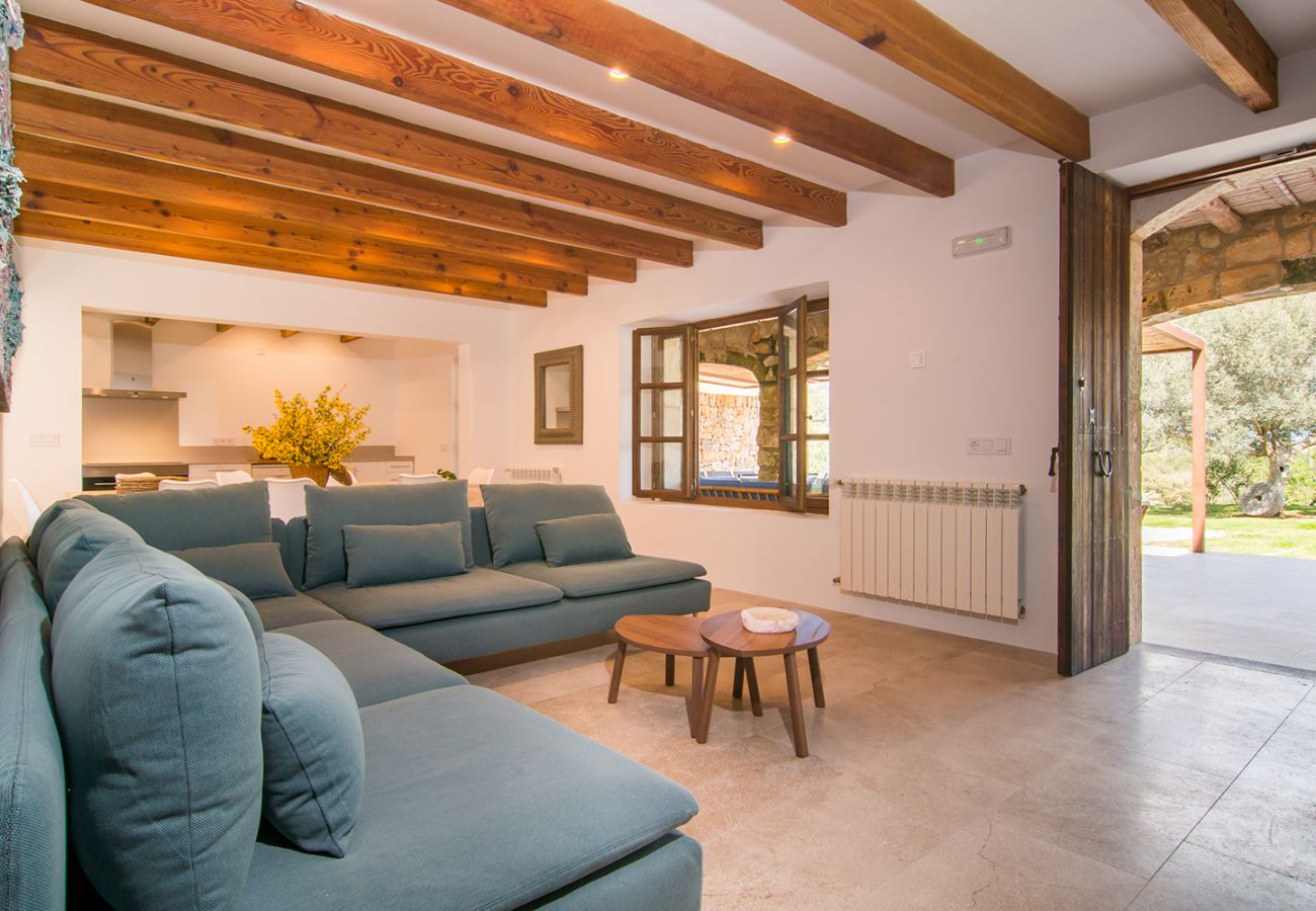 Stilvolles Wohnzimmer mit Sofa und offener Küche der Finca Es Rafal de Sant bei Son Servera